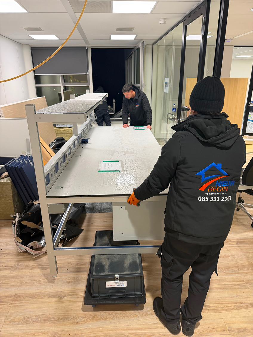 Verhuizer van Nieuw Begin zet een werkplek neer bij een bedrijfsverhuizing