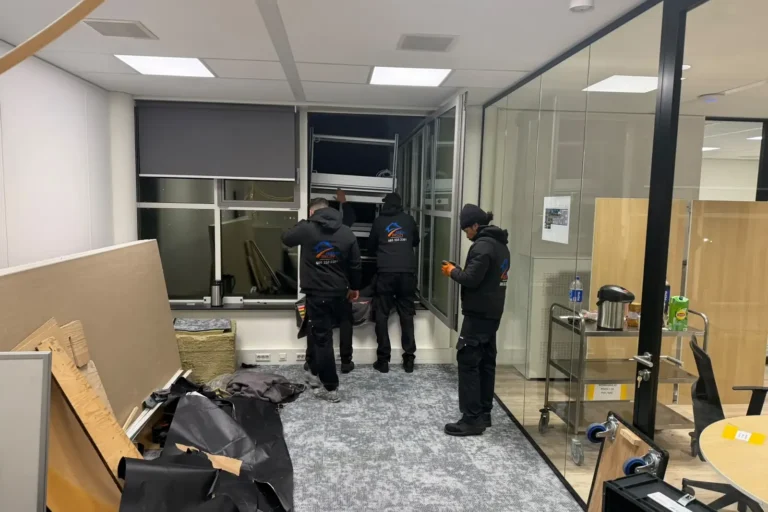 Verhuizers in een leeg kantoor bij het raam