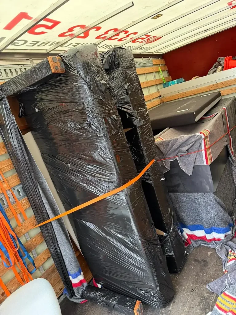 Een bank in folie, vastgezet met spanbanden in de wagen