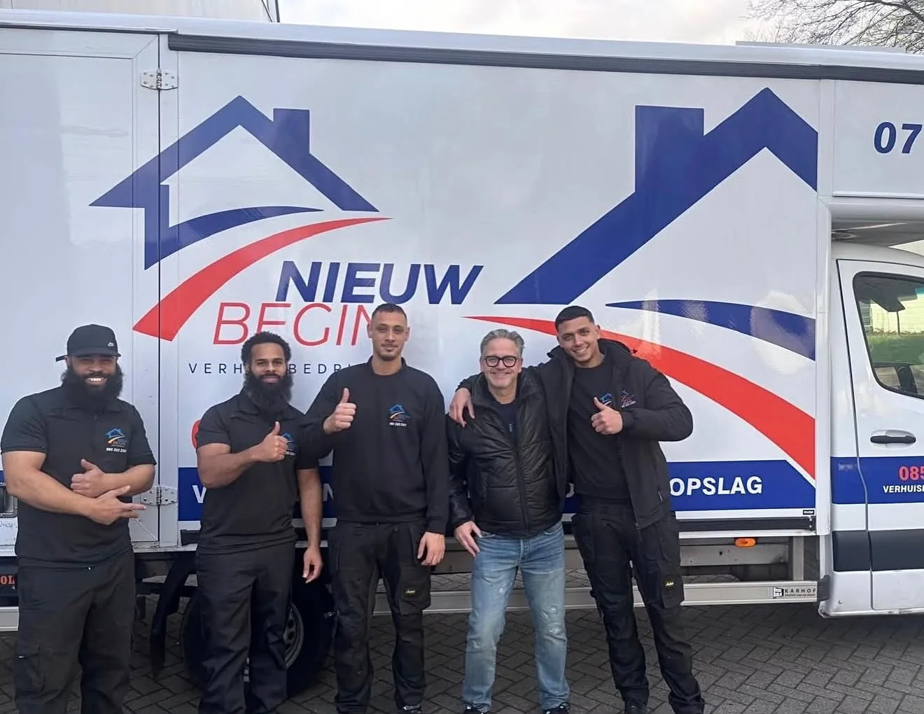 De ploeg van Nieuw Begin voor de wagen met het logo