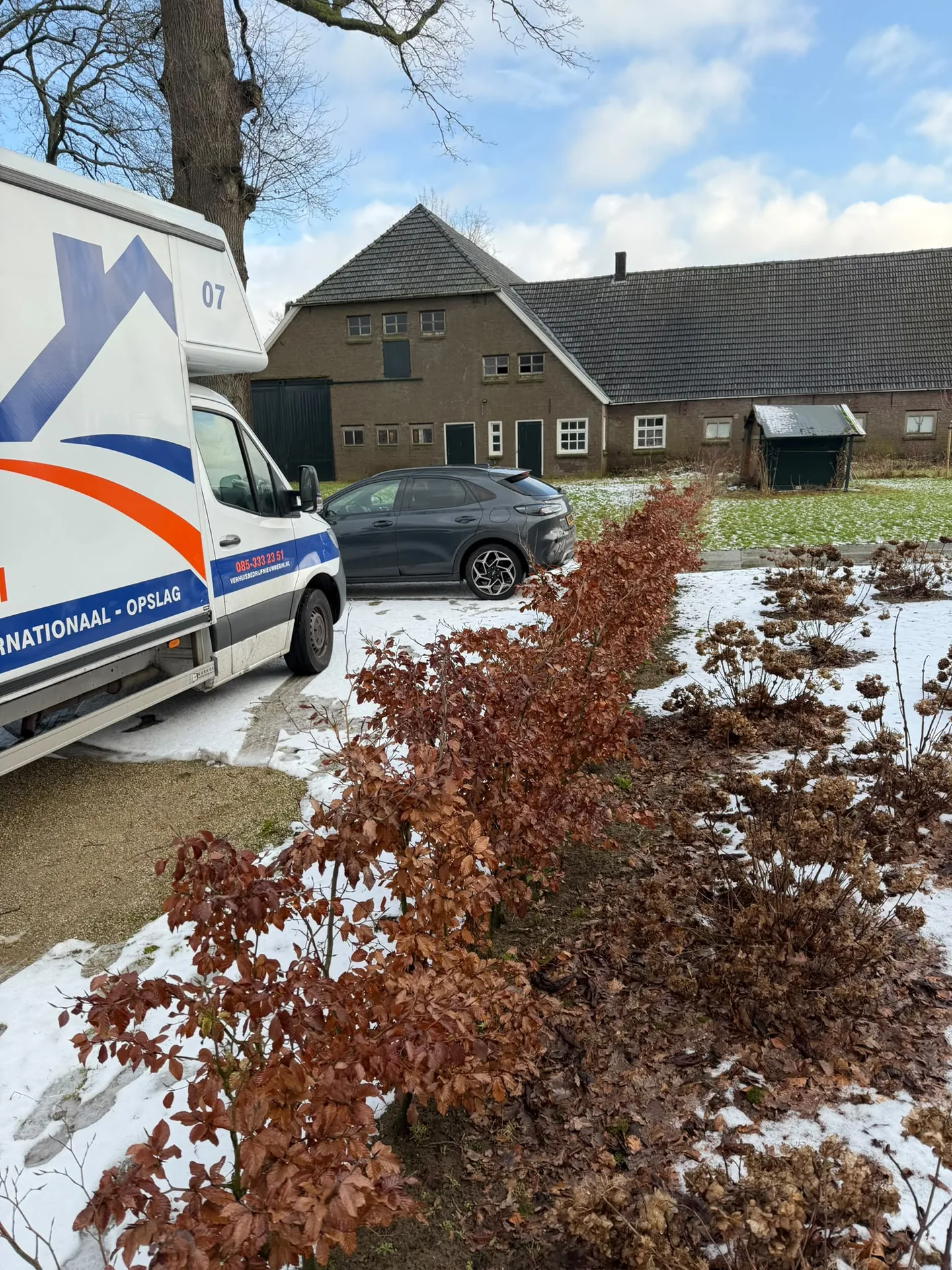 De verhuiswagen van Nieuw Begin bij een boerderij in de sneeuw