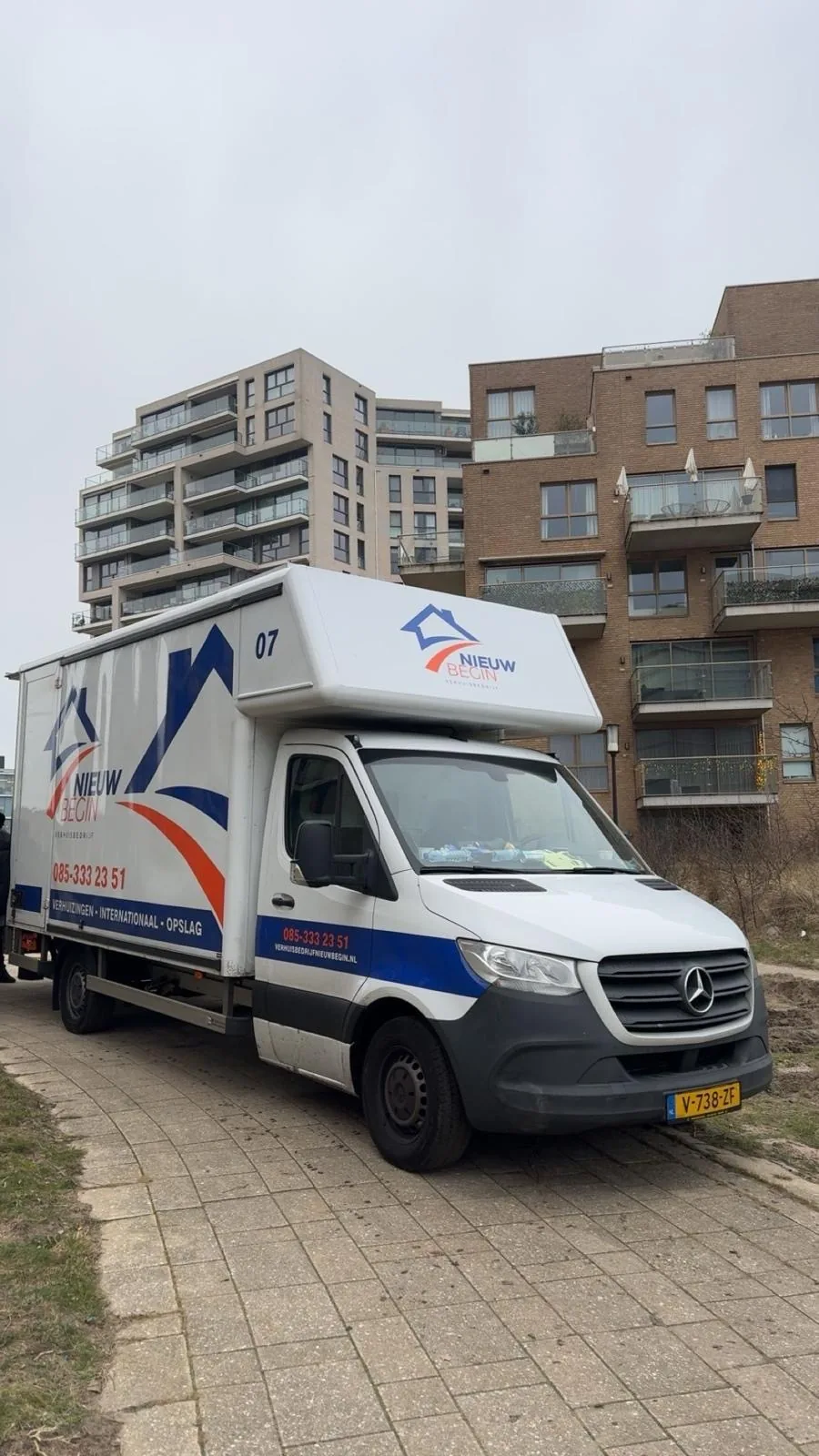 De verhuiswagen van Nieuw Begin voor een appartementencomplex
